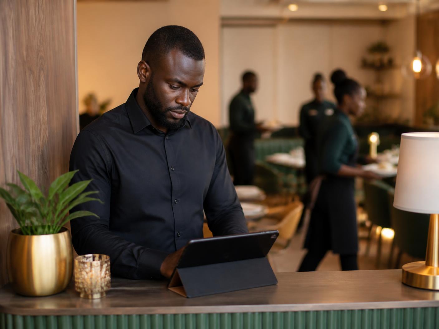 Responsable de restaurant consultant un terminal tablette au comptoir